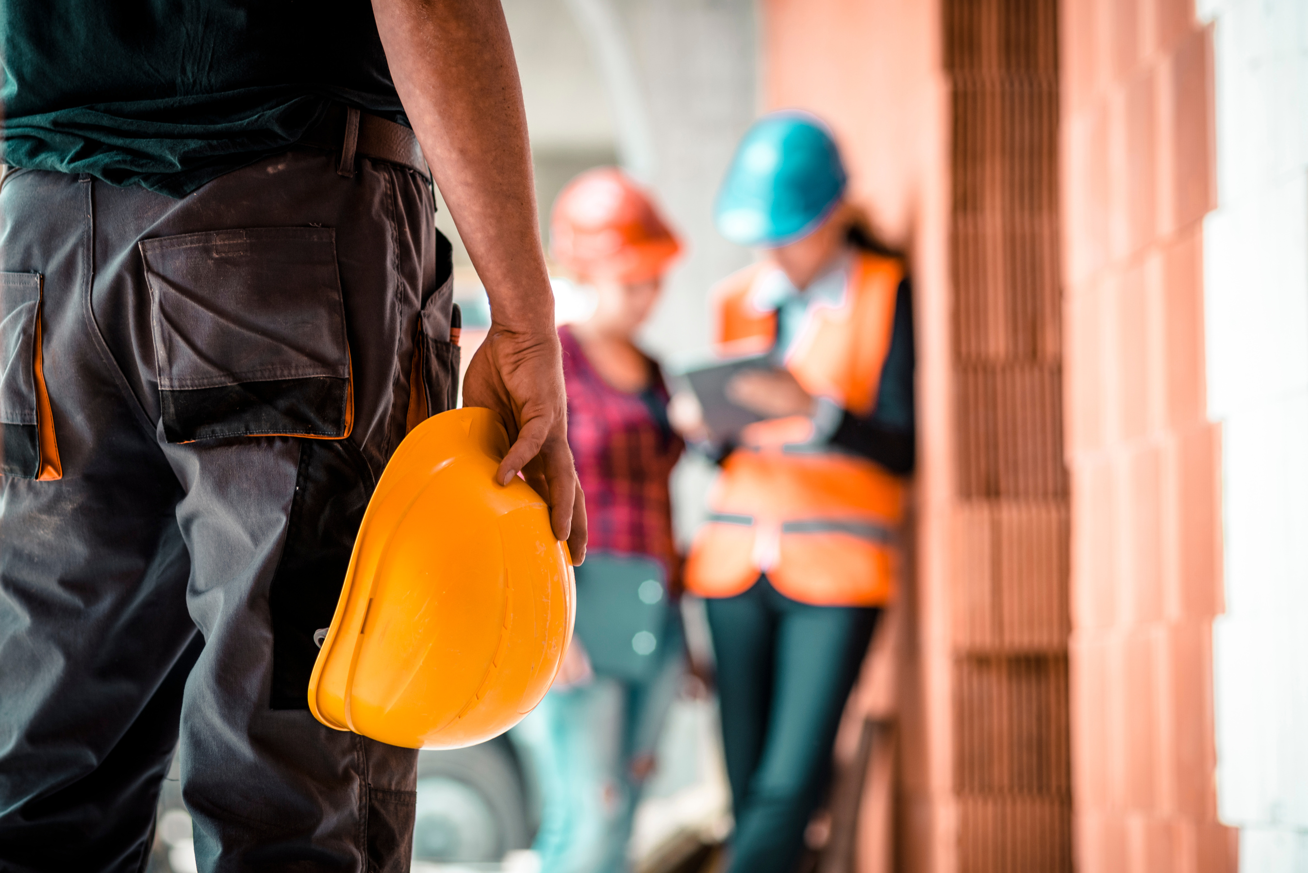 Construction worker holding safety helmet
